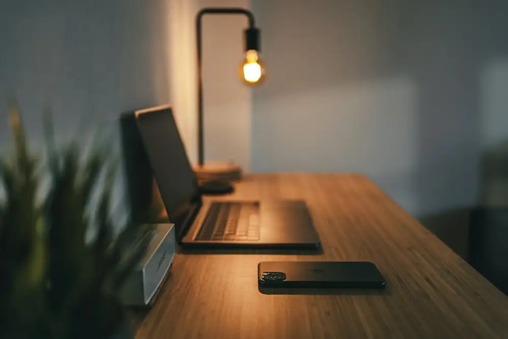 A laptop on a video call next to a mug